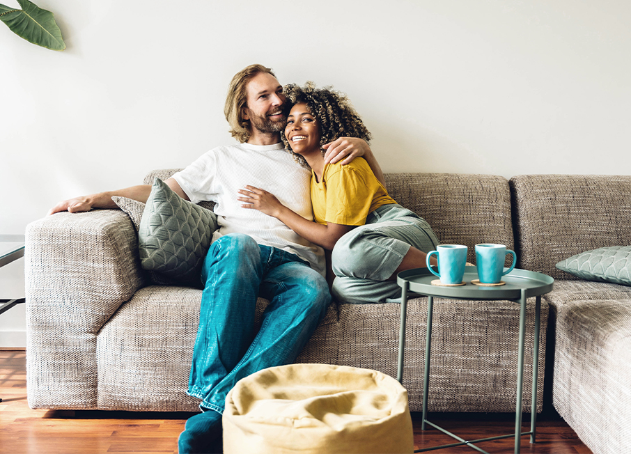 Couple relaxing on furniture in living room